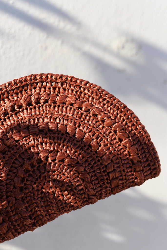 Detail of the crochet raffia moon clutch in rust