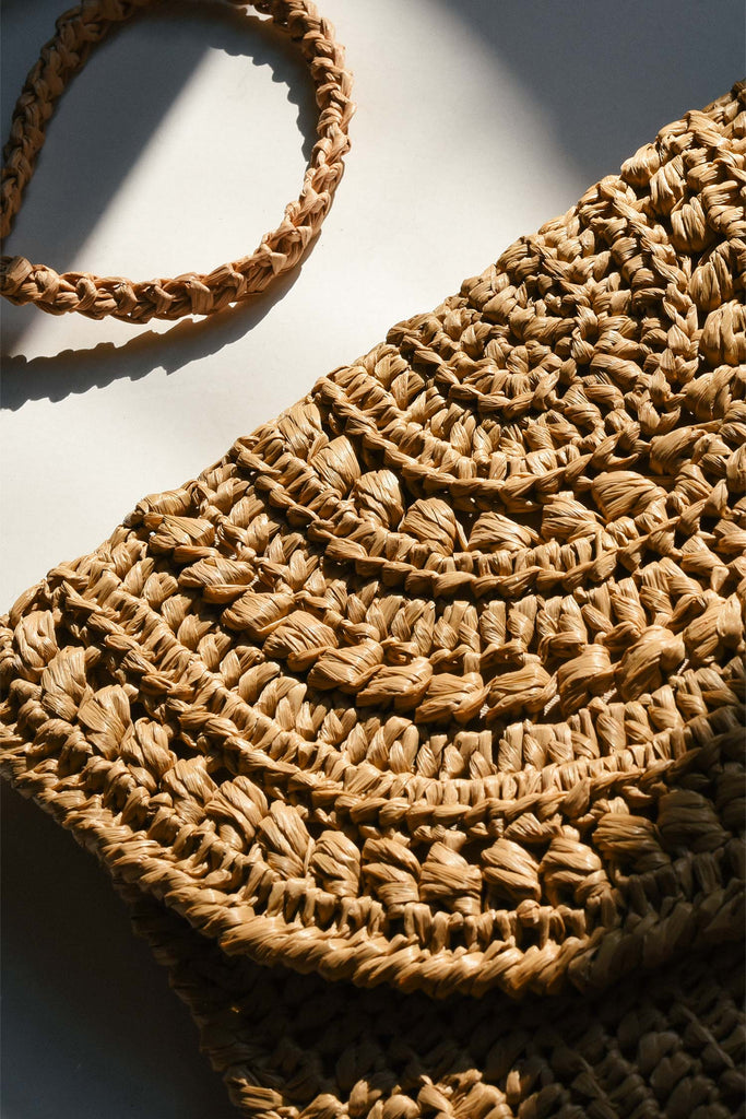 Detail of the handmade crochet raffia bag in tan color