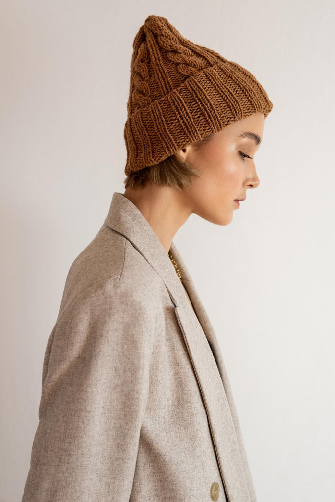 Side view of the hand knit cable hat in caramel